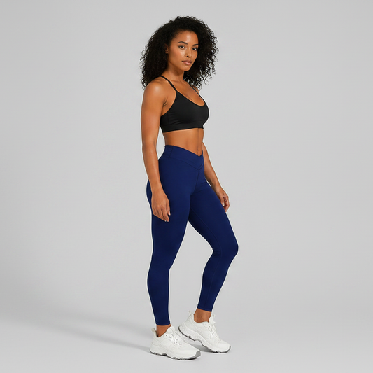Woman wearing a black sports bra and blue leggings on a gray background-Aresfit