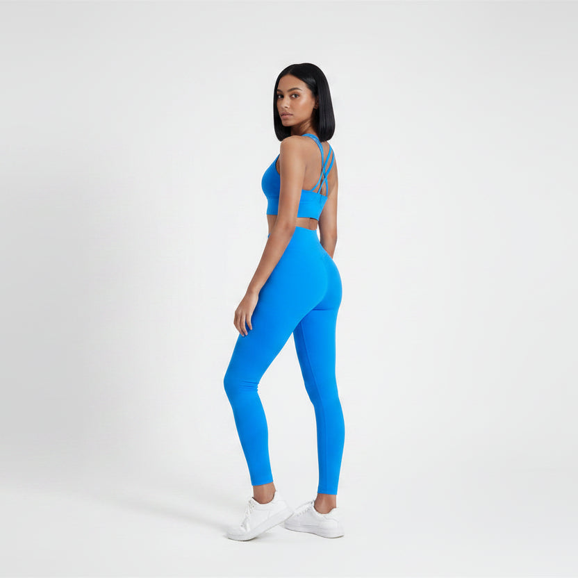Blue sports bra and leggings on a plain background- Aresfit