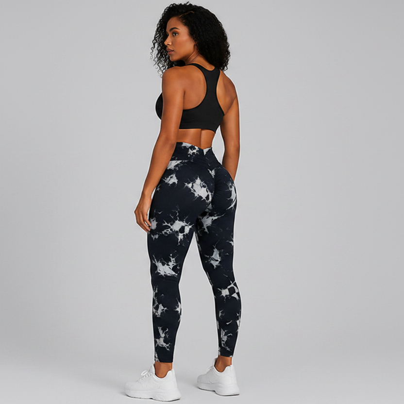 Person wearing black and white tie-dye leggings with a plain background - Aresfit