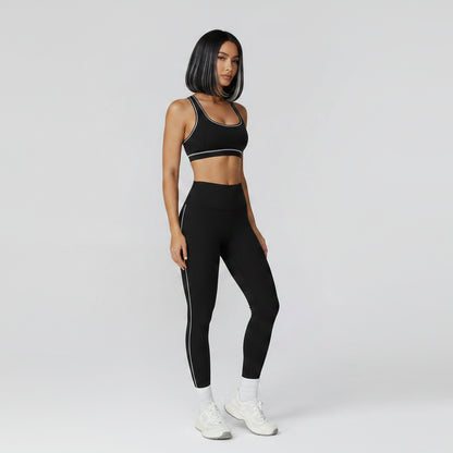 Person wearing a black sports bra and leggings set on a light gray background - Aresfit