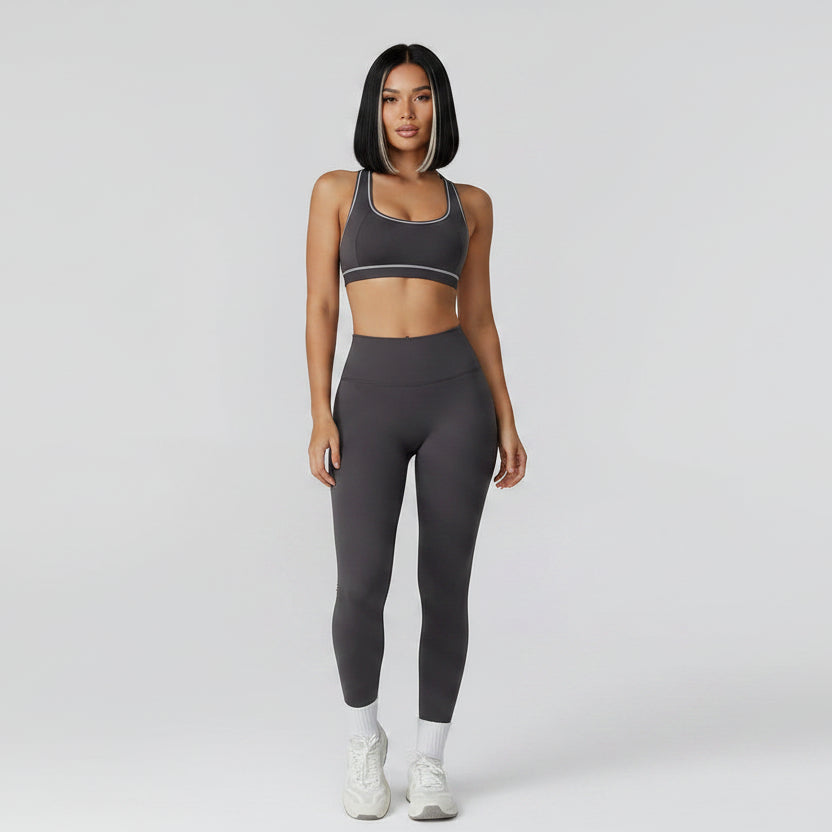 Person wearing a gray sports bra and leggings set on a light gray background - Aresfit