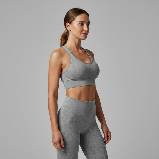 Woman wearing a gray sports bra on a white background - Aresfit