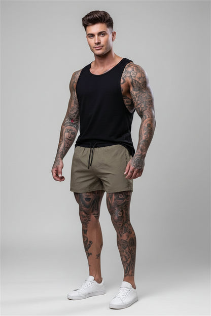man wearing shorts and a black tank top