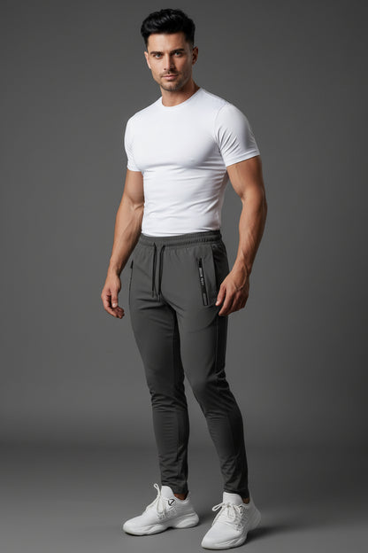 Person wearing gray jogger pants with zippers in a gym setting