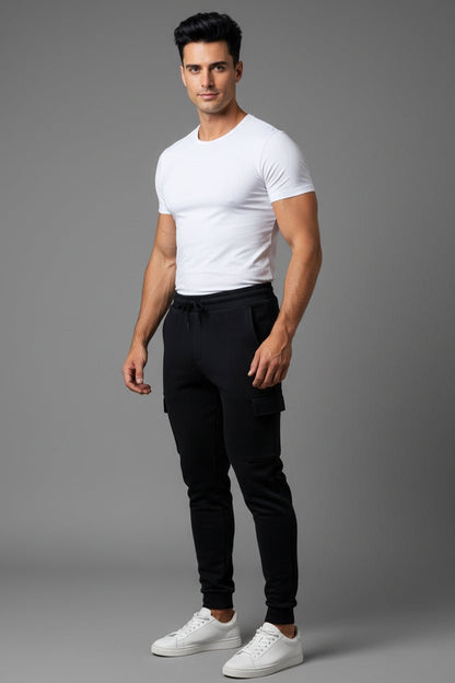 Man wearing a white t-shirt and black pants on a gray background