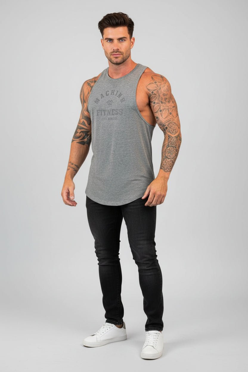 Man wearing a gray tank top with text and black pants on a light gray background