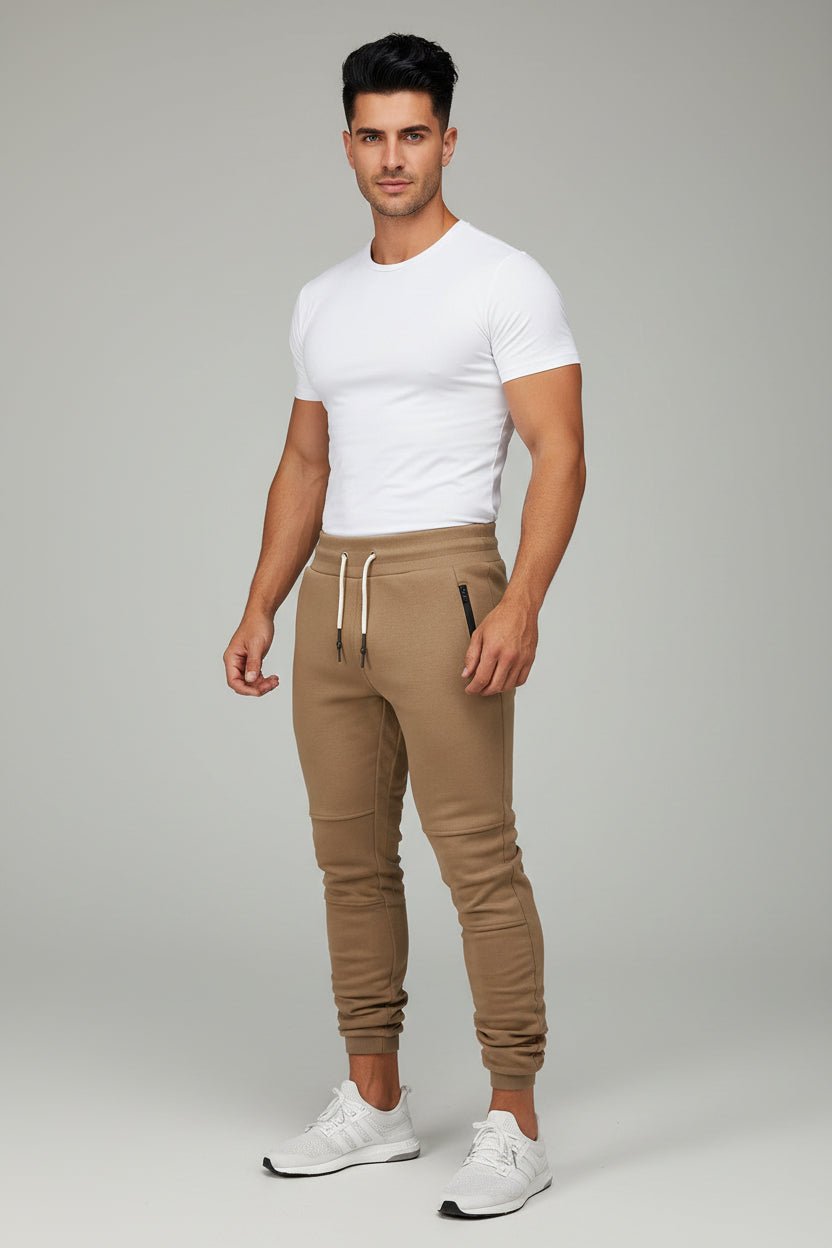 Man wearing beige gym jogger pants and white fitted t-shirt