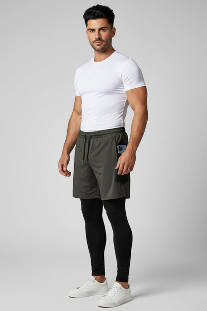 Man wearing a white t-shirt, gray shorts, and black leggings on a light gray background