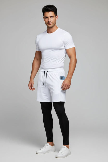 Man wearing a white t-shirt, white shorts, black leggings, and white sneakers on a gray background