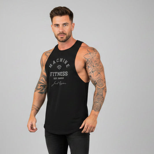 Man wearing a black tank top with text and black pants on a gray background