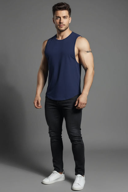 Man wearing a navy tank top and black pants on a gray background