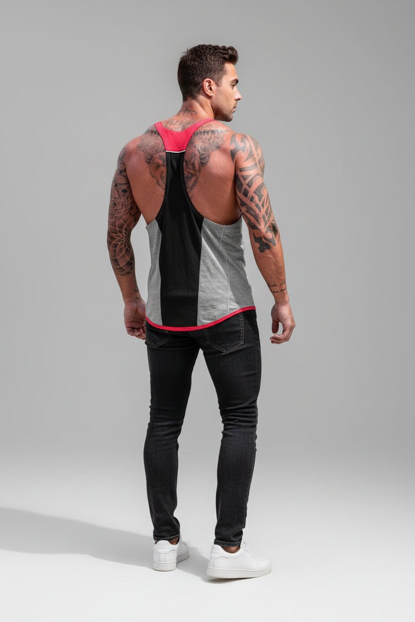 Man wearing a black and gray tank top with red accents and black pants on a gray background