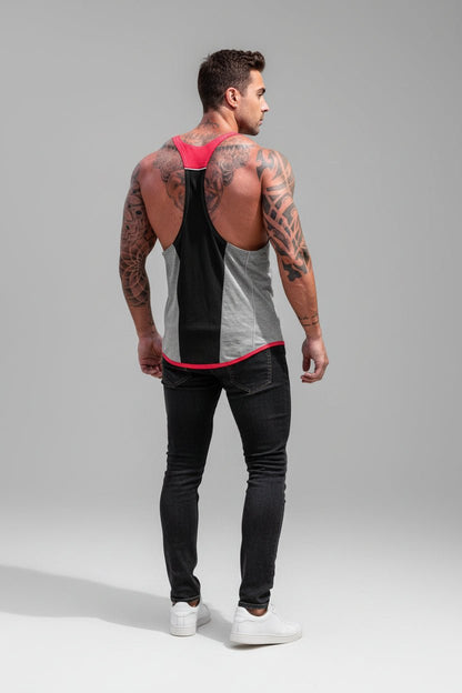 Man wearing a black and gray tank top with red accents and black pants on a gray background