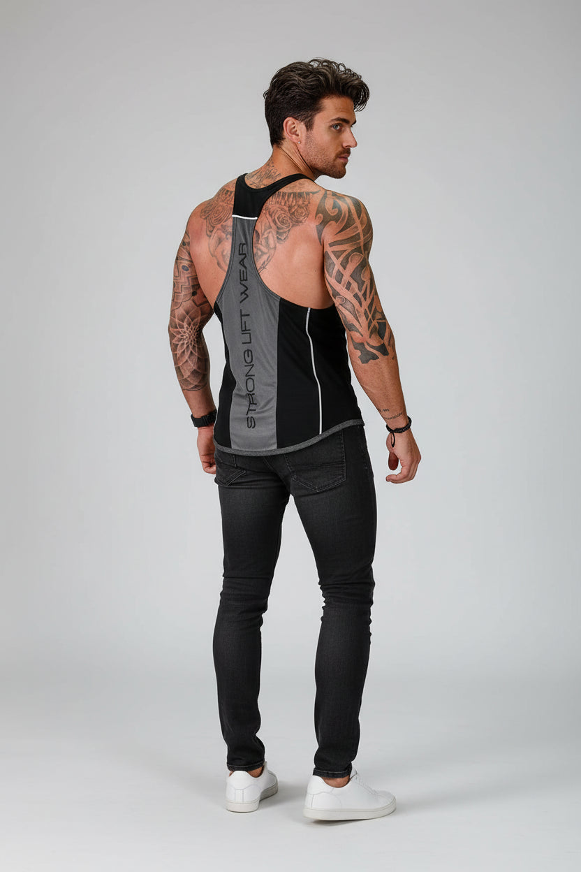 Man wearing a black tank top with visible branding and black pants on a gray background