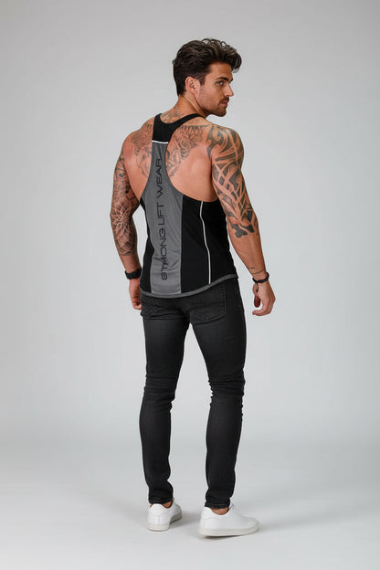 Man wearing a black tank top with visible branding and black pants on a gray background