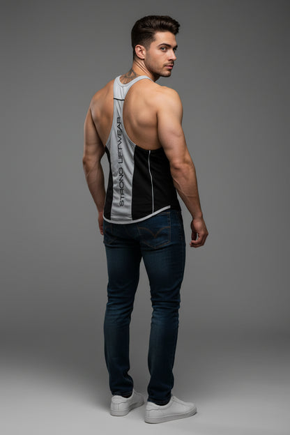 Man wearing a tank top and dark jeans on a gray background