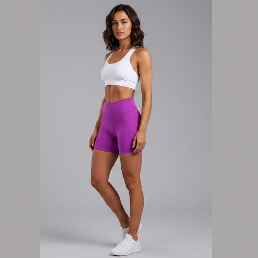 Woman wearing a white sports bra and purple shorts on a gray background - Aresfit
