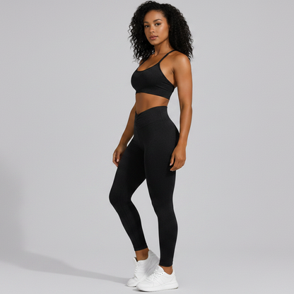 Woman wearing a black seamless sports bra and high waist leggings set on a gray background - Aresfit