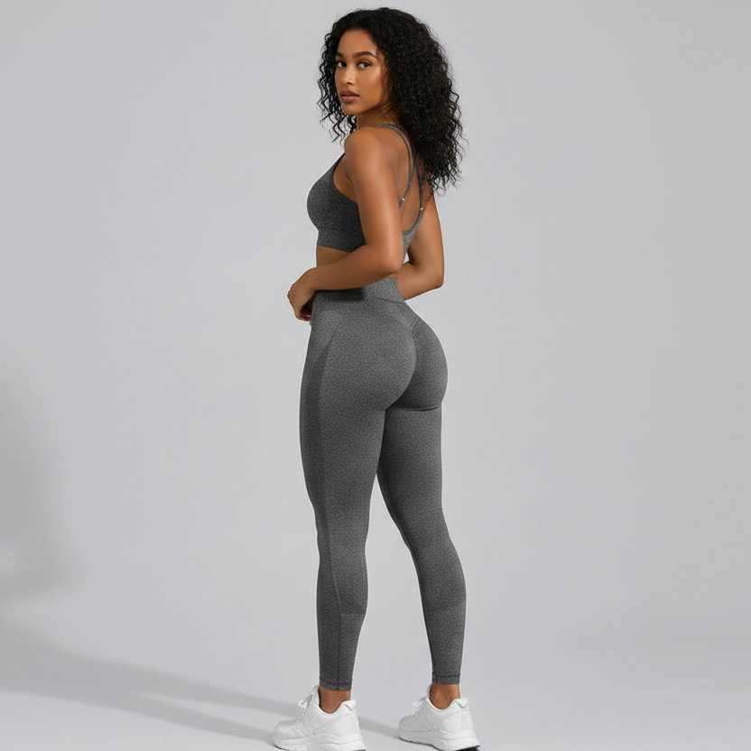 Woman wearing a gray seamless sports bra and high waist leggings set from the back on a gray background - Aresfit