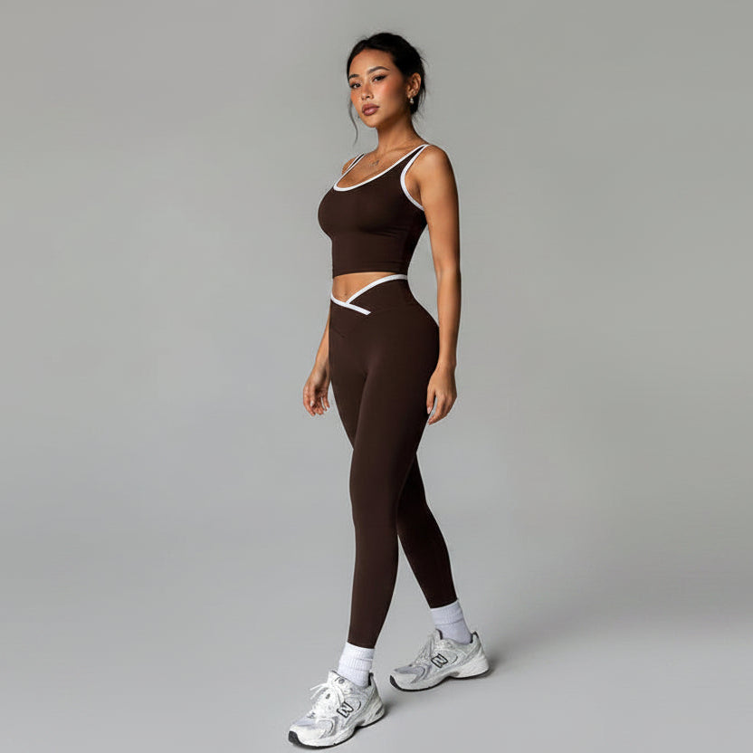 Woman wearing a brown athletic outfit with white sneakers on a gray background- AresFit