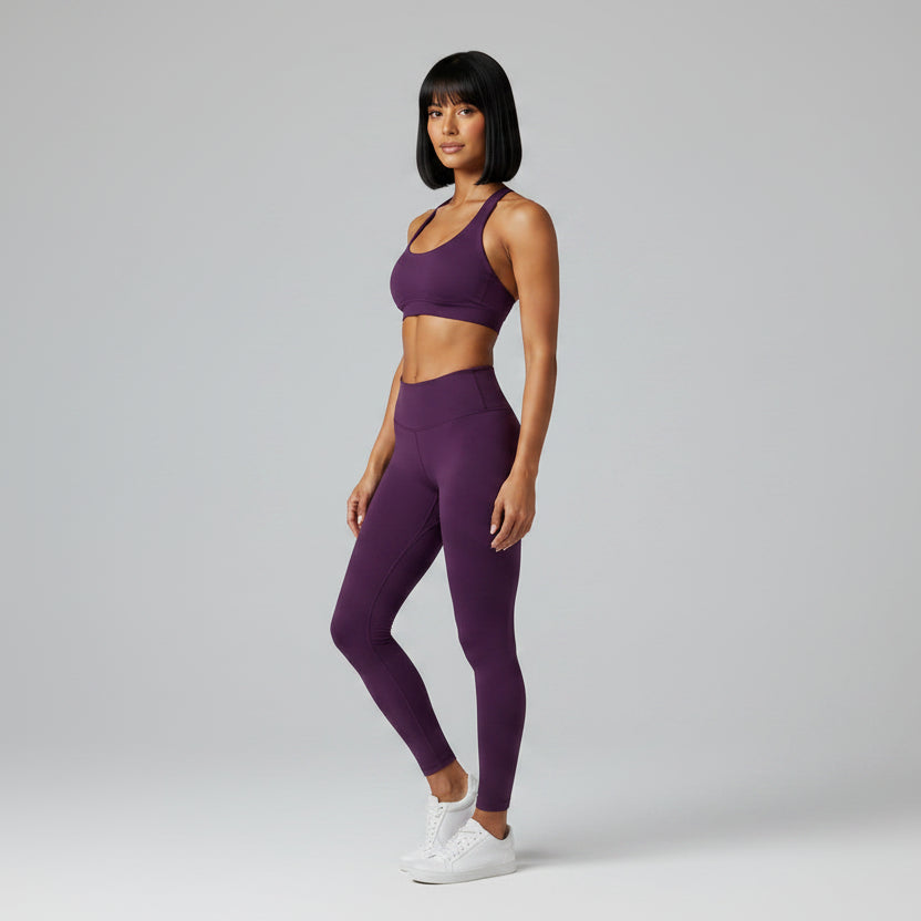 Woman wearing a dark purple gym top and dark purple leggings - AresFit
