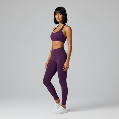 Woman wearing a dark purple gym top and dark purple leggings - AresFit