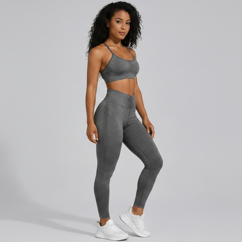 Woman wearing a gray seamless sports bra and high waist leggings set on a gray background - Aresfit